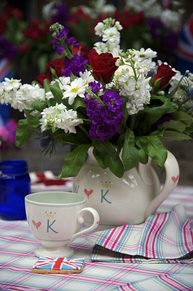 Blumenstrauss in weißem Keramikkrug und passender Tasse