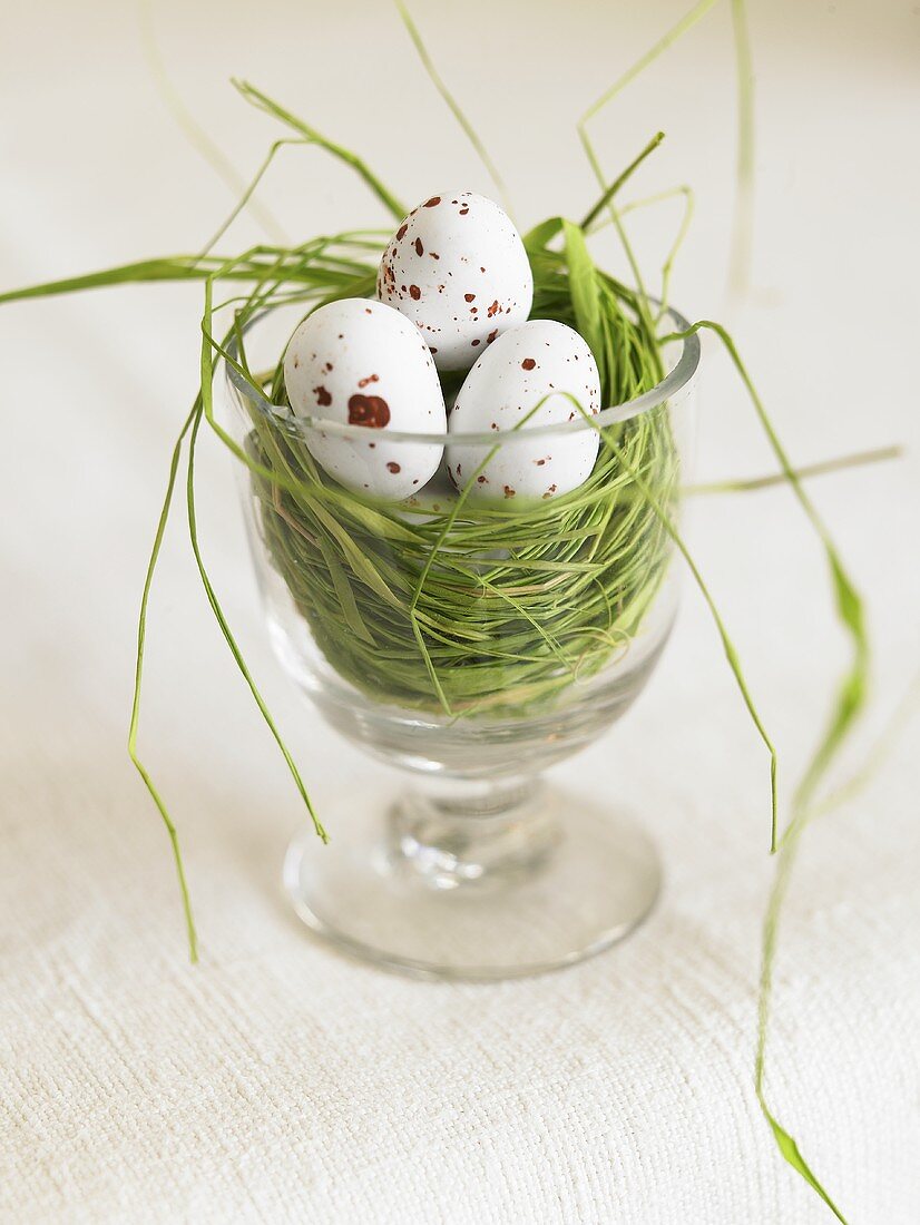 A nest in a glass with speckled eggs
