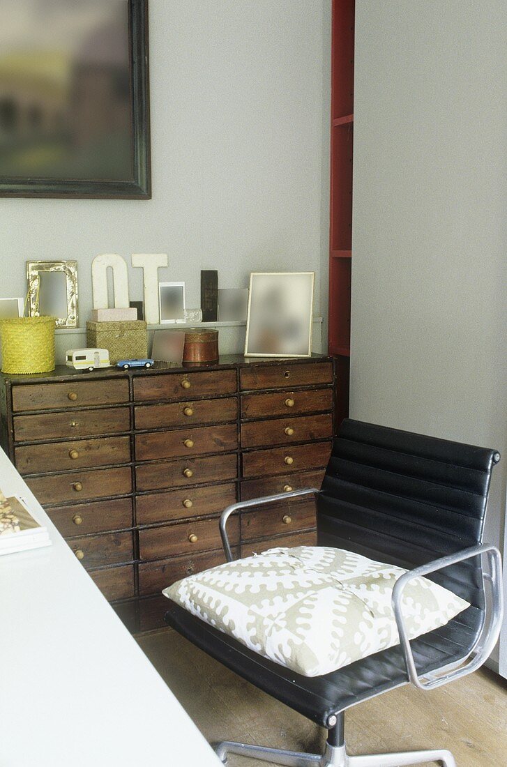 A black office chair and a wooden drawer unit