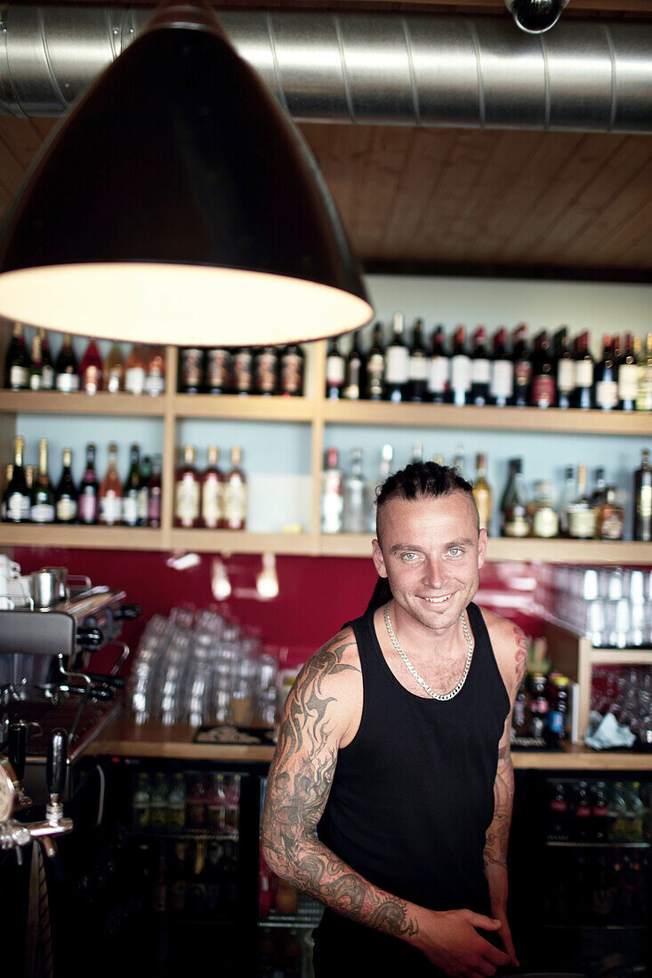Varis ist Barkeeper im angesagten Cabo Café, Restaurant und Wassersport Verleih am See Kisezers, Stadtteil Mezaparks, Riga, Lettland