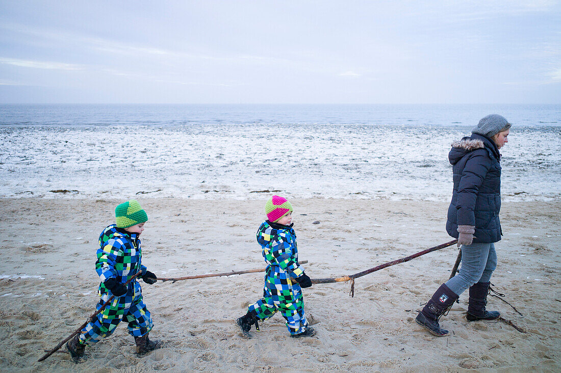 Junge Mutter geht mit ihren Söhne am Strand spazieren, Cuxhaven, Nordsee, Niedersachsen, Deutschland
