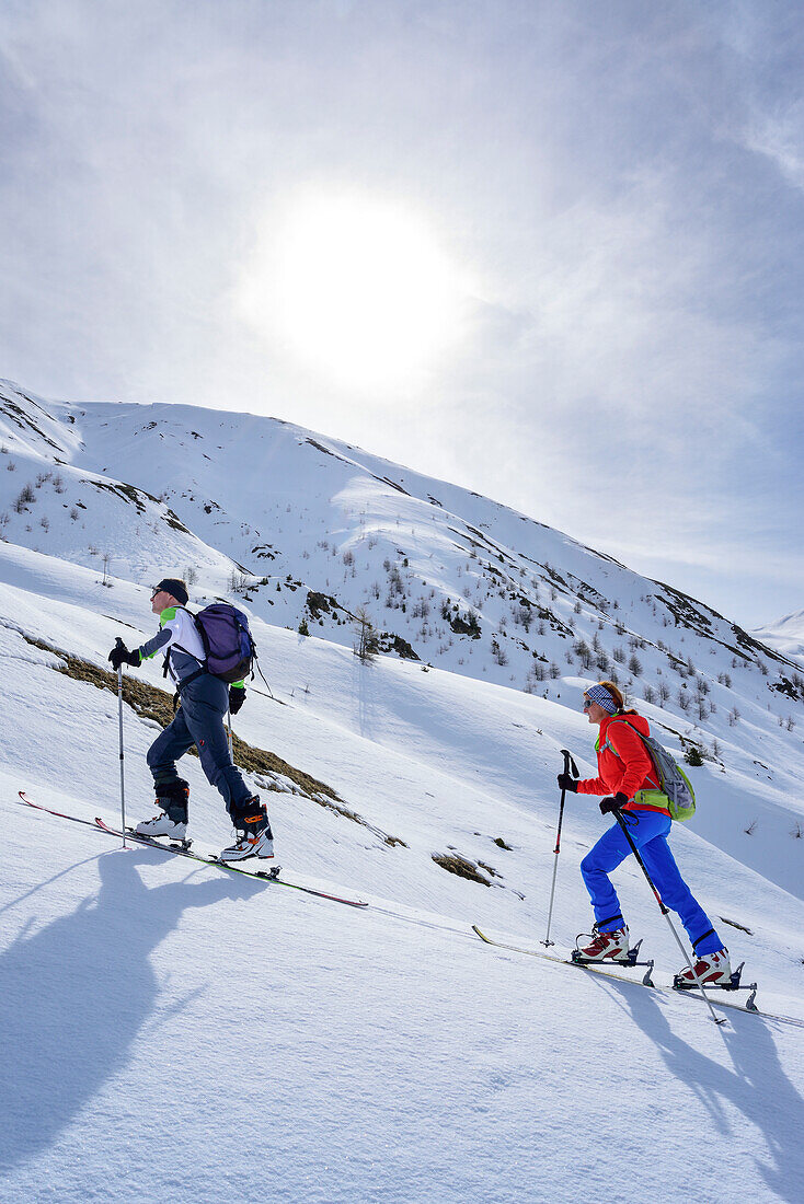 Two persons back-country skiing ascending towards Piz Arpiglia and Piz Uter auf, Piz Arpiglia, Livigno Alps, Engadin, Grisons, Switzerland