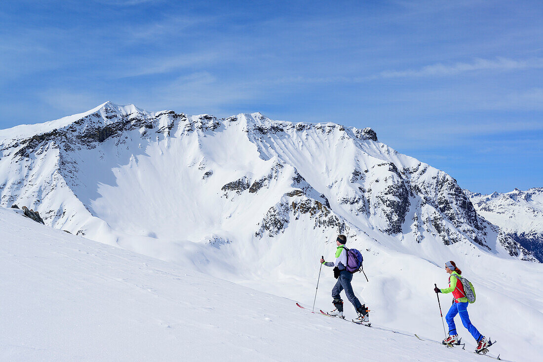 Two persons back-country skiing ascending towards Piz Arpiglia and Piz Uter auf, Piz Arpiglia, Livigno Alps, Engadin, Grisons, Switzerland