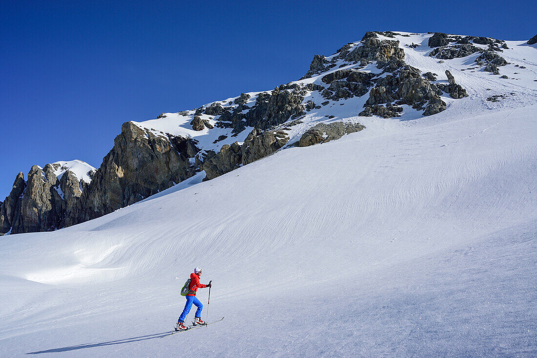 Woman back-country skiing ascending towards Piz Lischana, Piz Lischana, Sesvenna Alps, Engadin, Grisons, Switzerland
