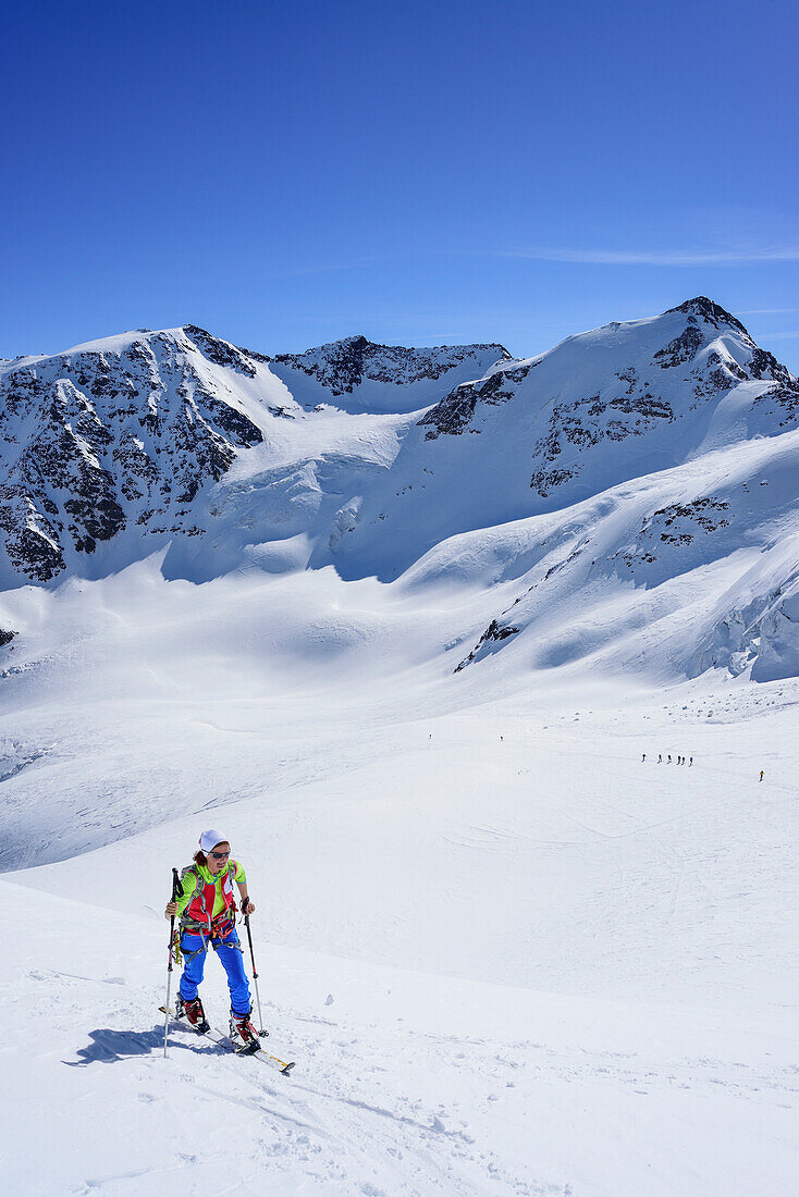 Frau auf Skitour steigt zur Punta San Matteo auf, Punta Taviela und Punta Cadini im Hintergrund, Punta San Matteo, Val dei Forni, Ortlergruppe, Lombardei, Italien