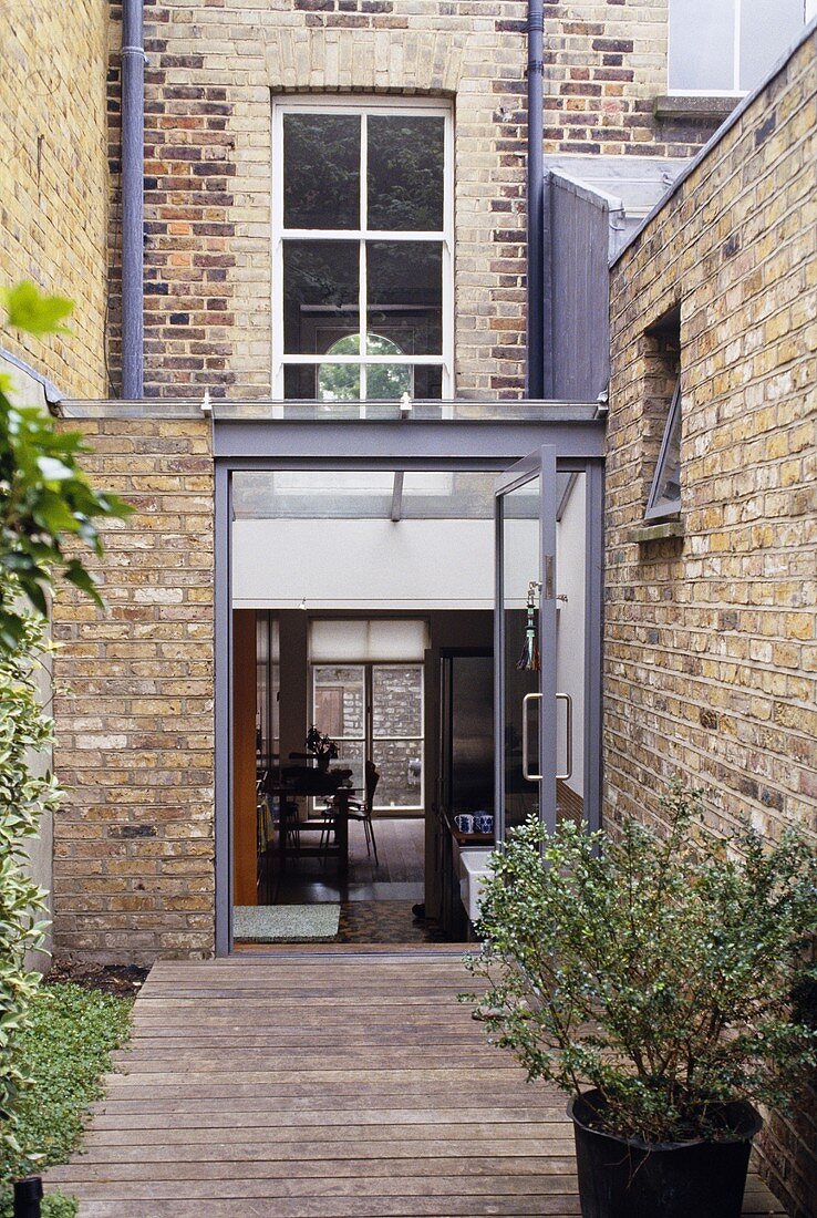 A renovated town house with a brick facade and a conservatory