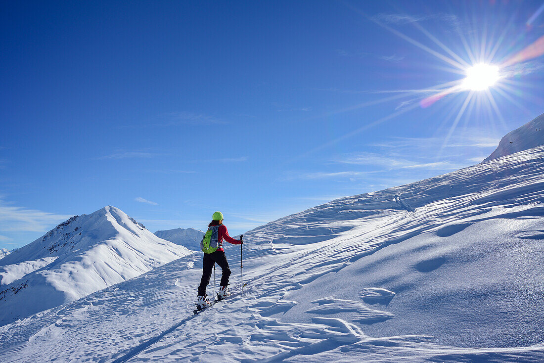 Woman back-country skiing ascending towards Munt Buffalora, Piz Daint in background, Munt Buffalora, Ofenpass, Sesvenna range, Engadin, Grisons, Switzerland