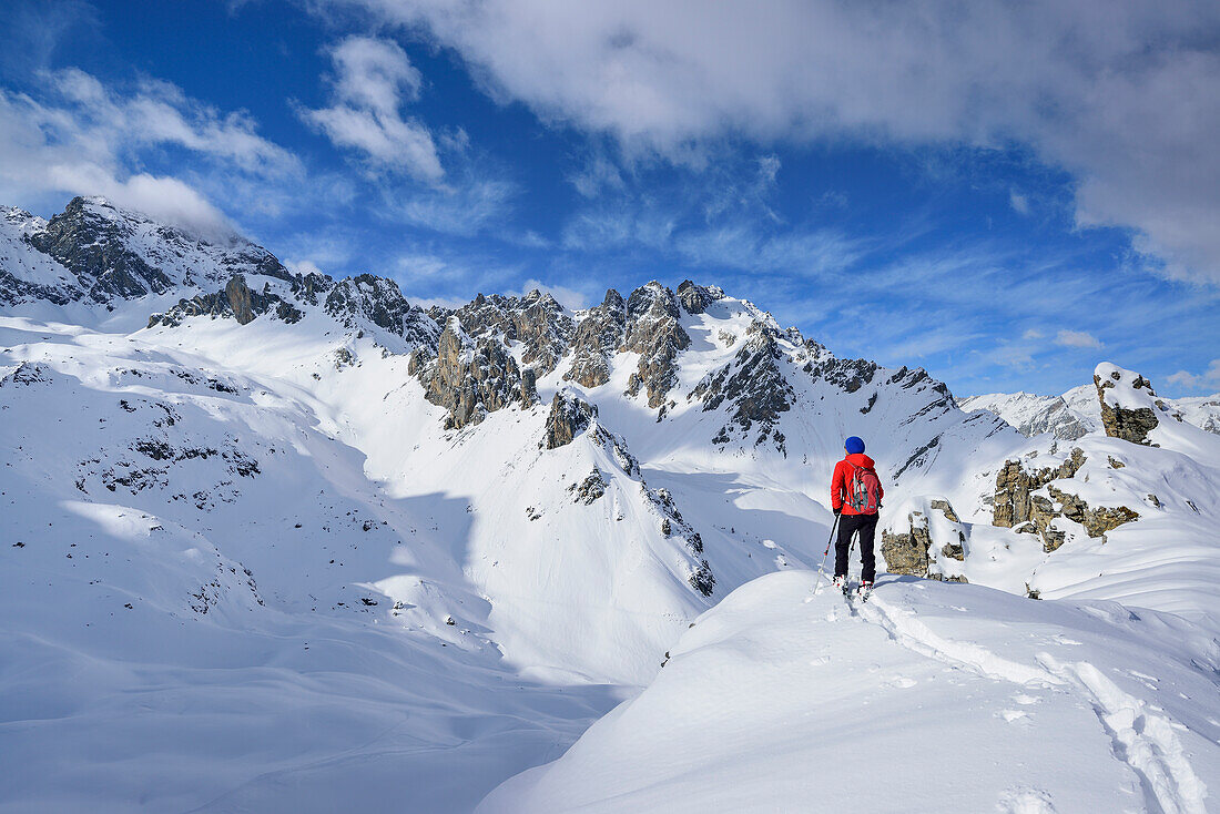 Frau auf Skitour blickt ins Tal Vallonasso di Sautron, Monte Soubeyran, Valle Maira, Cottische Alpen, Piemont, Italien