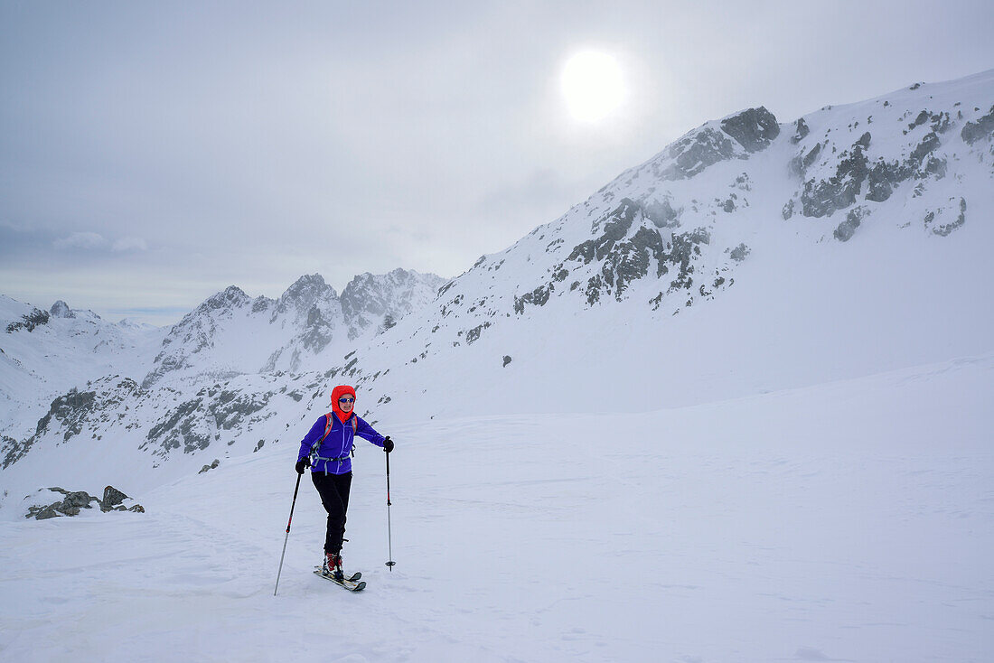 Frau auf Skitour steigt bei Schlechtwetter zum Colle della Scaletta auf, Colle della Scaletta, Valle Maira, Cottische Alpen, Piemont, Italien