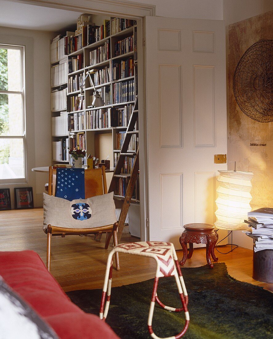 A living room with an open door and a view of the book case