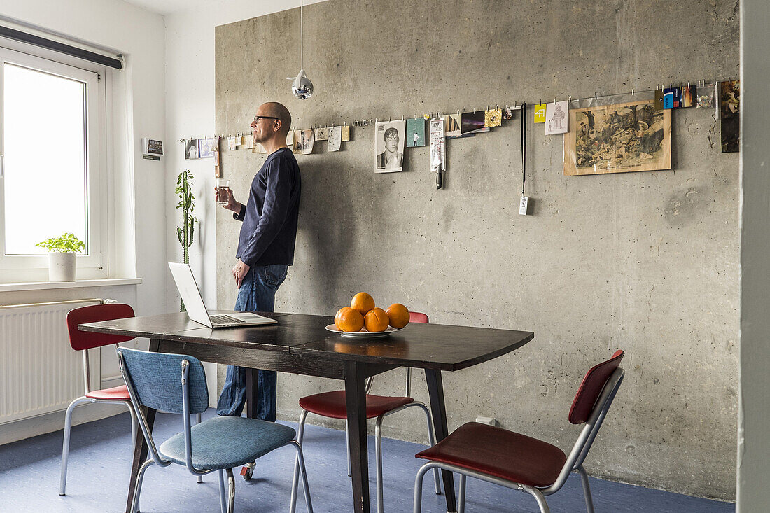 Mann in einer modernisierte Plattenbauwohnung am Alexanderplatz, Berlin, Deutschland