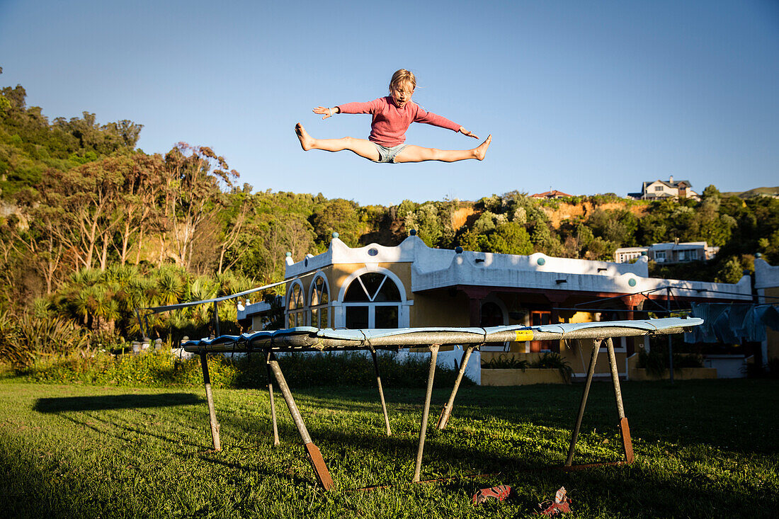 A girl jumping on the trampoline at the Sans Souci Inn, Pohara, Golden Bay, South Island, New Zealand