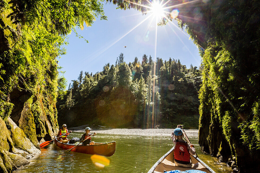 Two girls and a woman on a canoe trip on the Whanganui River, North Island, New Zealand