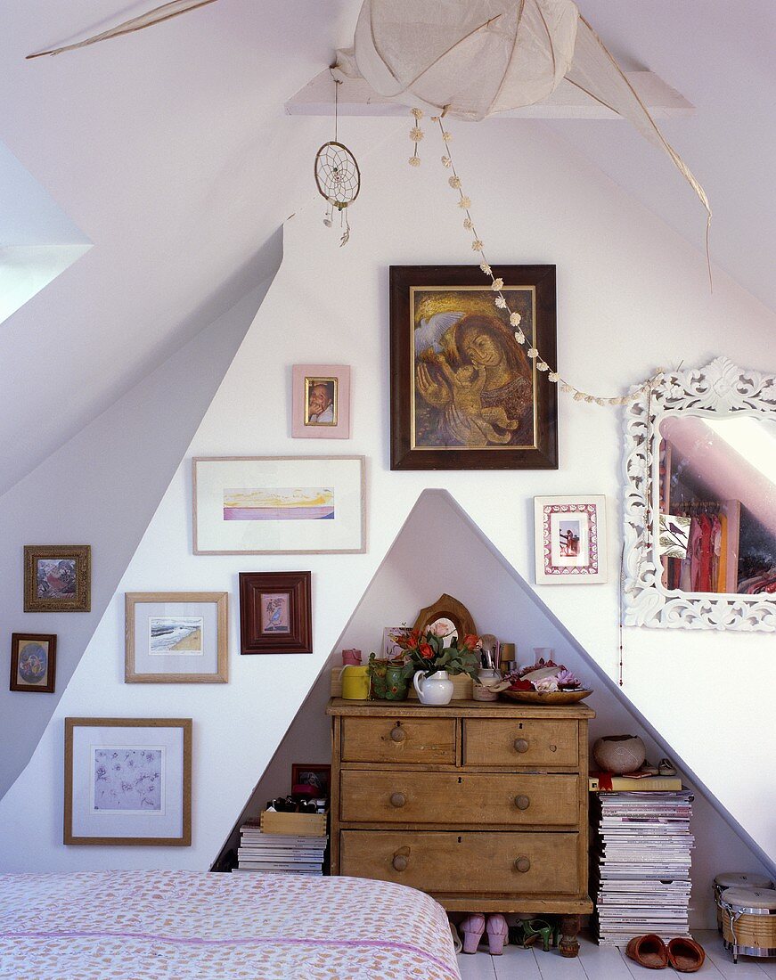 Bedroom in a converted attic with wood chest-of-drawers in a wall niche