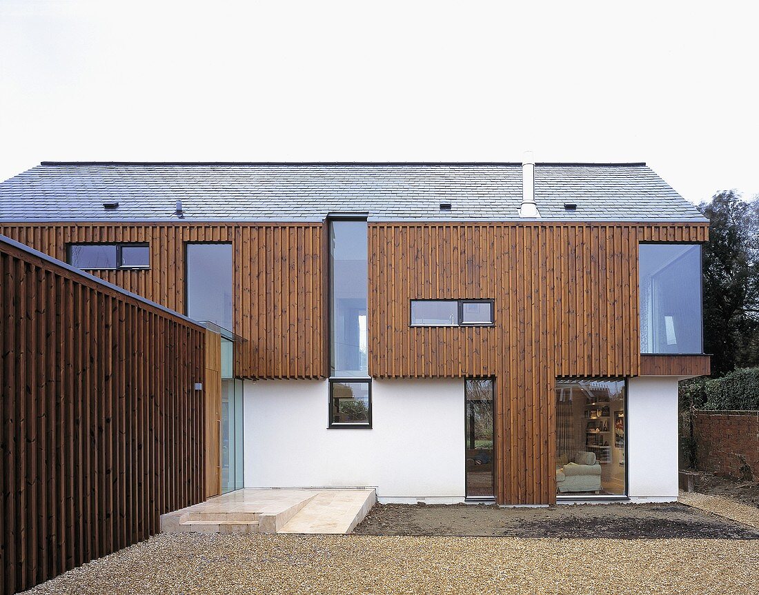 A new house built partially with wood panelling with floor-to-ceiling windows