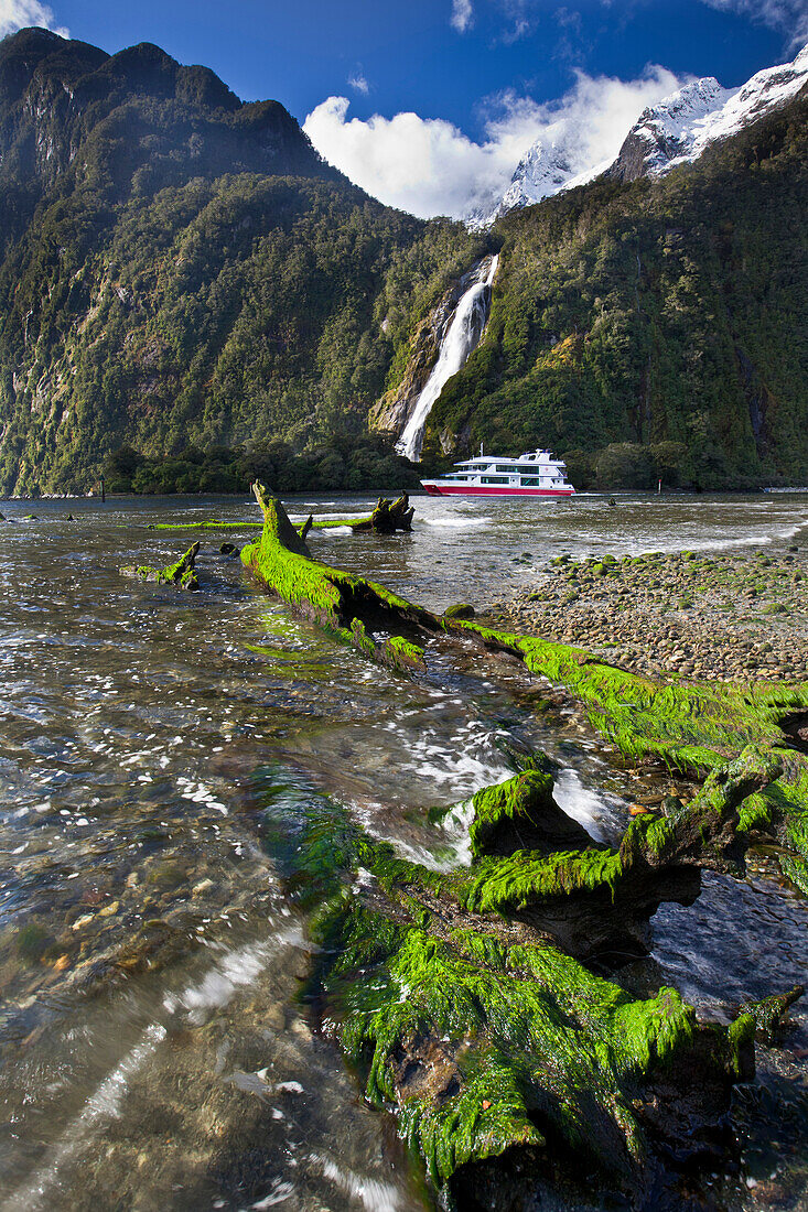 Bowen Falls with cruise vessel passing, Milford Sound, Fjordland National Park, New Zealand