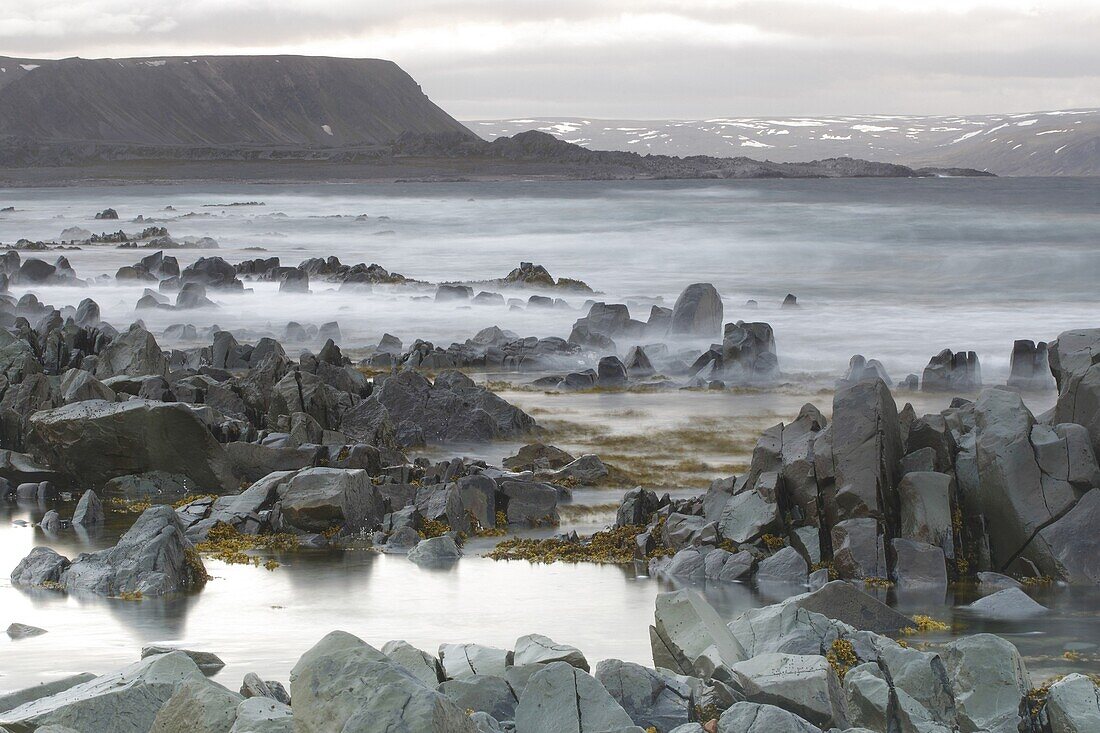 Stormy coastline and snowy peaks, Varangerfjord, Norway