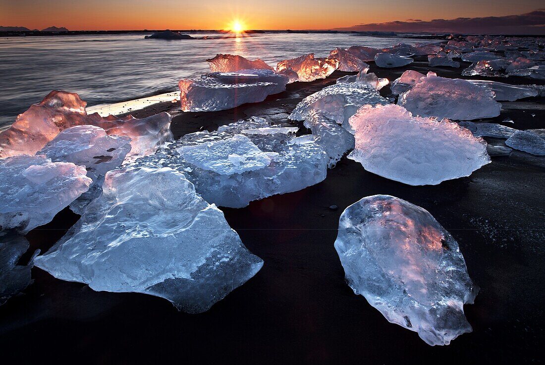 Chunks of ice on coastline near Jokulsarlon at sunset, Iceland