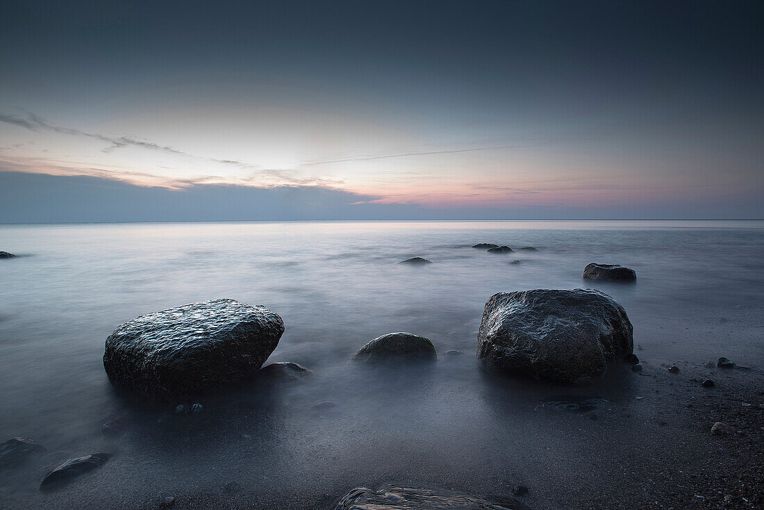 Große, abgeschliffene Stein am Kiesstrand an der Ostsee in der Abendstimmung, Wustrow, Darß, Mecklenburg Pommern, Deutschland