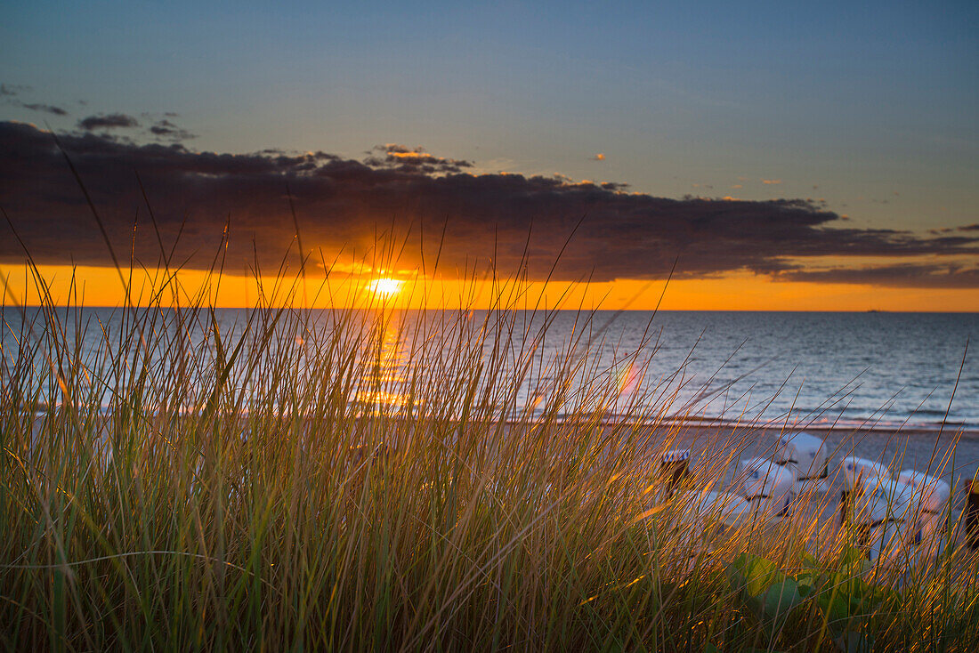 Sunset on a Baltic beach with dune grass and beach chairs, Dierhagen, Mecklenburg Vorpommern, Germany