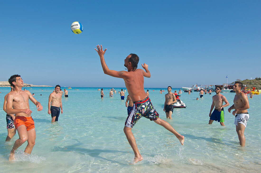 Männer spielen Volleyball  im flachen Wasser am Nissi Beach bei Agia Napa nordöstlich von Larnaka, Larnaca District, Zypern