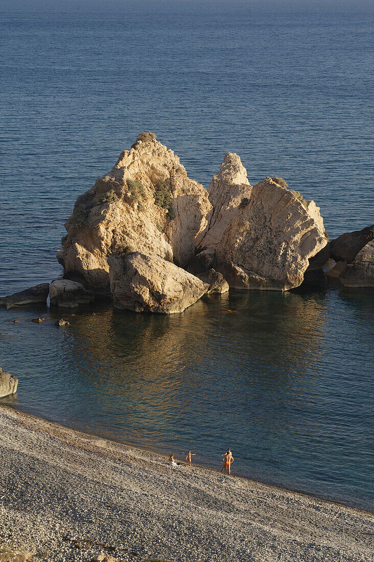 Pebble beach and people bathing in the sea at Petra tou Romiou, Aphrodites rock, Paphos, Cyprus