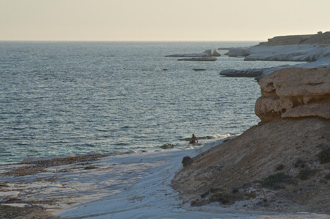 Weisse Felsen am Governor's Beach, einsamer Strand mit Kieseln und einem Badenden, Limassol, Zypern