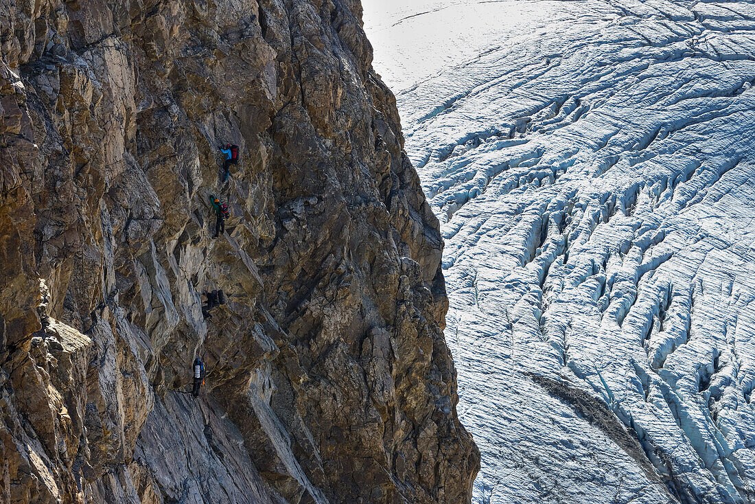 Climbers in the via ferrata at Piz Trovat with view to the Pers glacier, Engadin, Grisons, Switzerland