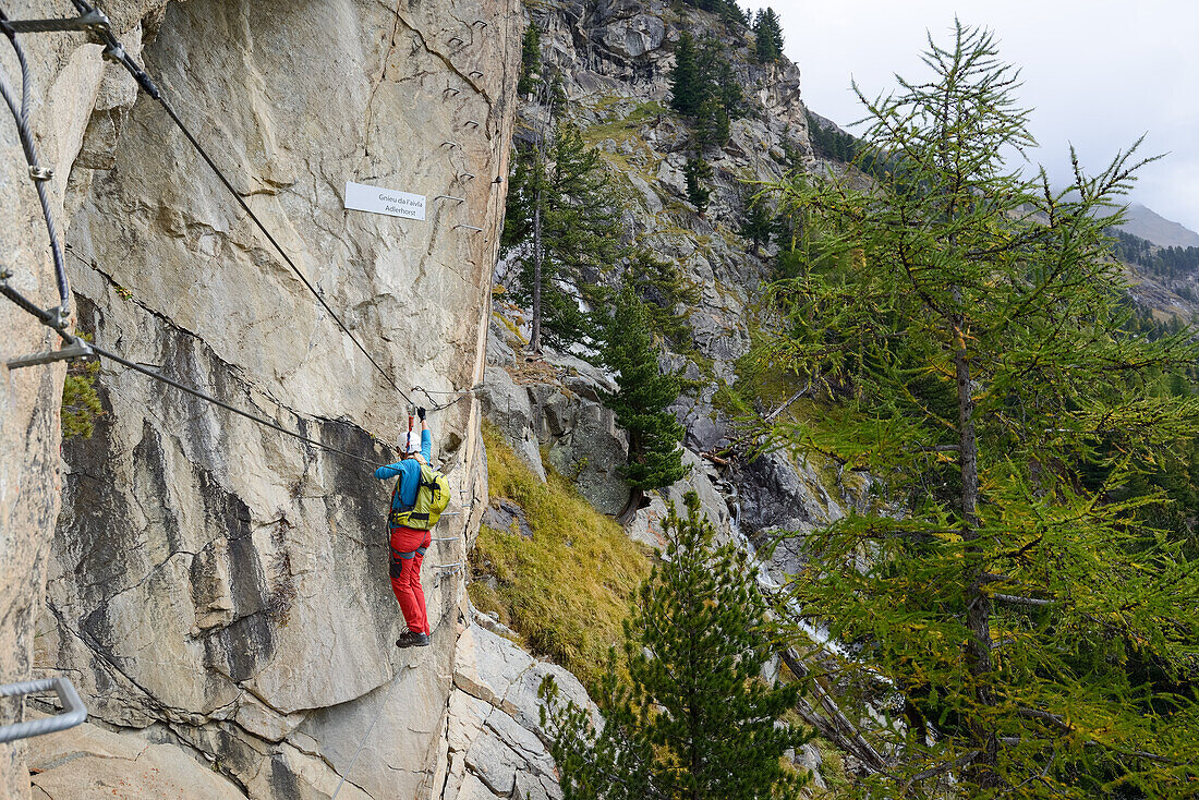 Woman climbing the via ferrata La Resgia, Engadin, Grisons, Switzerland