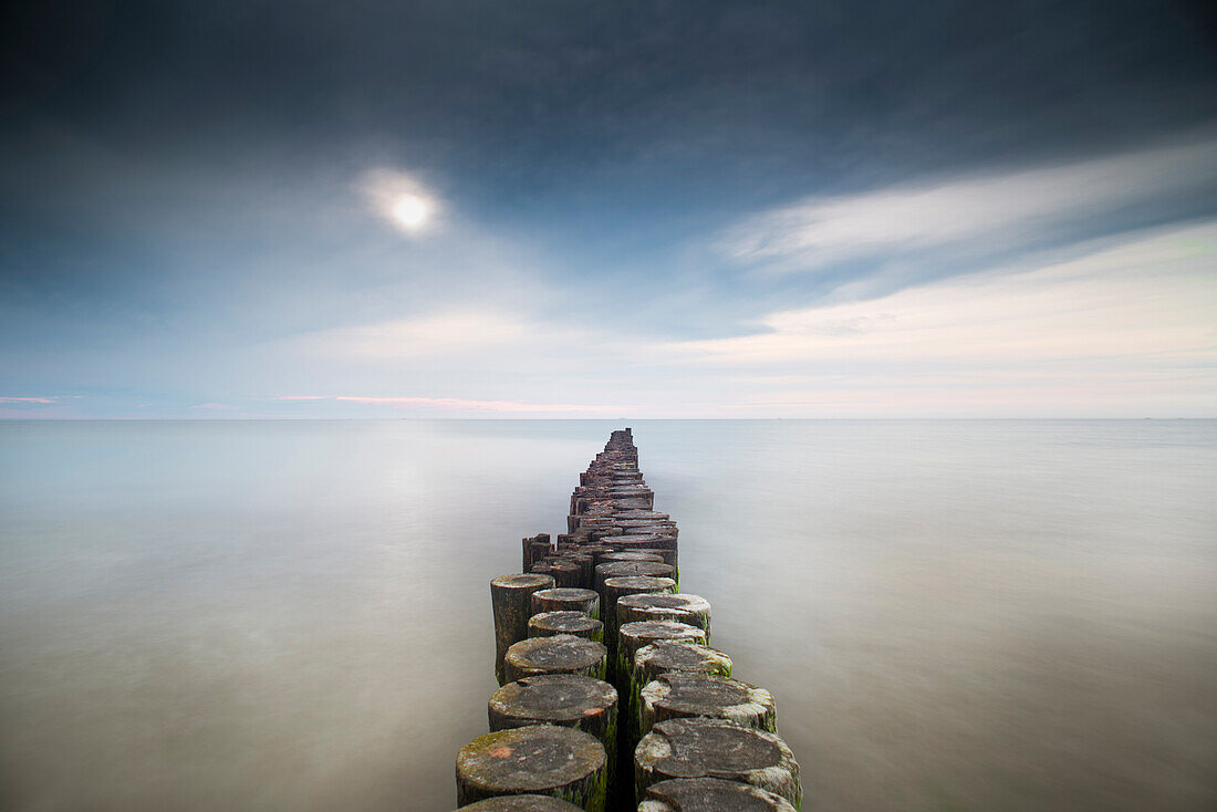 Groynes on the Baltic beach with clouds traces in the long exposure, Western Pomerania Lagoon Area National Park, Wustrow, Fischland-Darss-Zingst, Mecklenburg Vorpommern, Germany