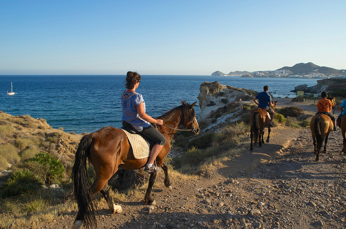Reiterin zu Pferd, Ausritt von San Jose an der felsigen Küste am Cabo de Gata in der Provinz Almeria, Andalusien, Spanien
