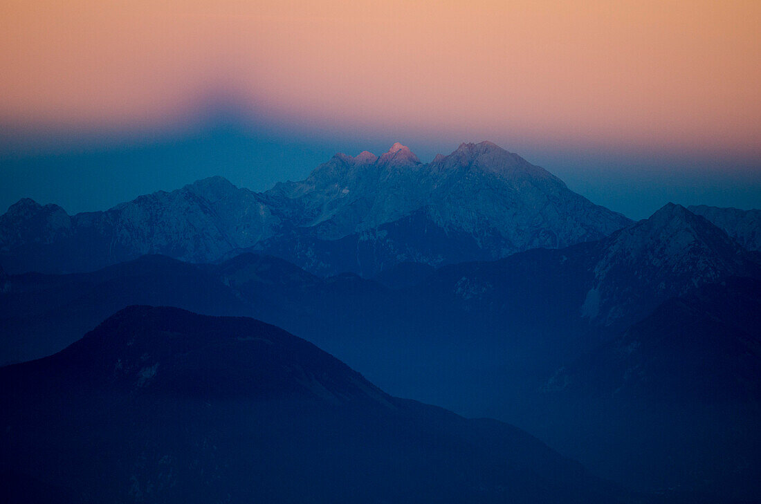 Der Triglav wirft während dem Sonnenuntergang seinen Schatten in den Himmel im Osten, Julische Alpen, Solwenien
