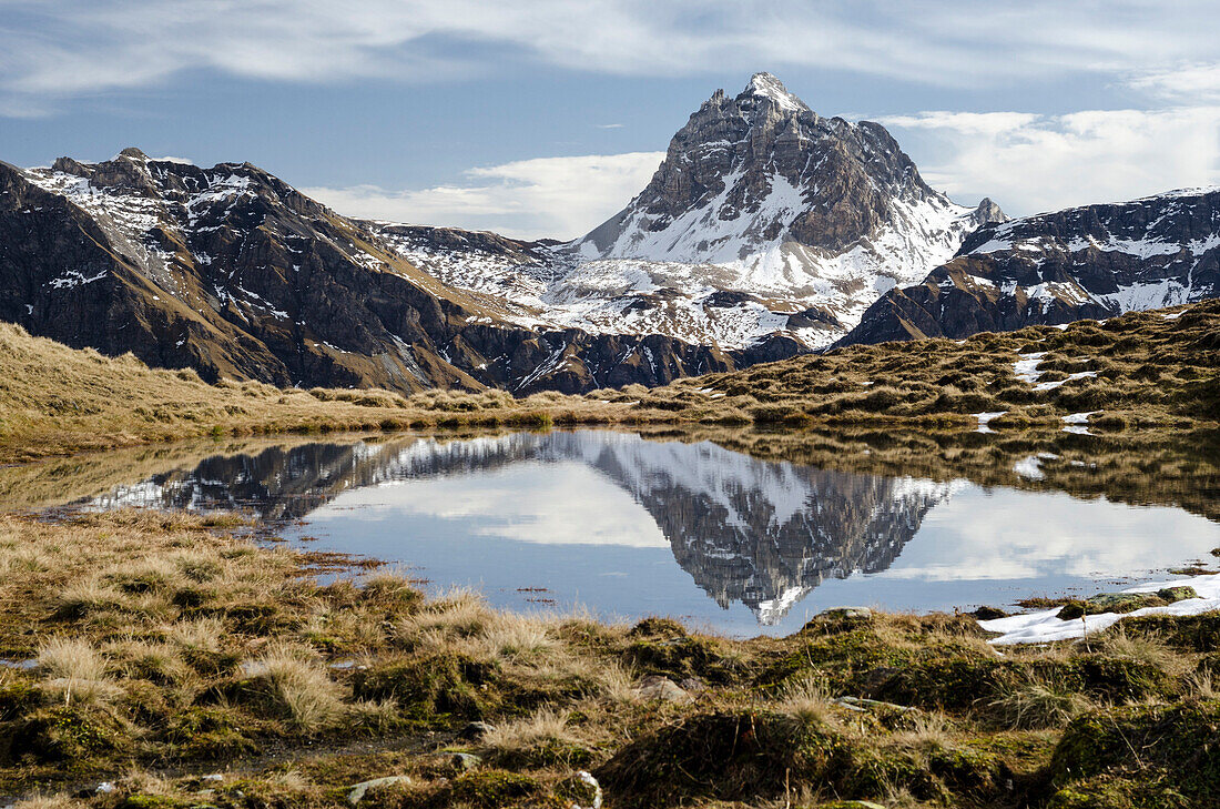 Mountain lake near Tomuel Pass with reflection of the Grauhoerner or Pizzas d'Anarosa, Safien Valley, Grison Alps, canton of Grison, Switzerland