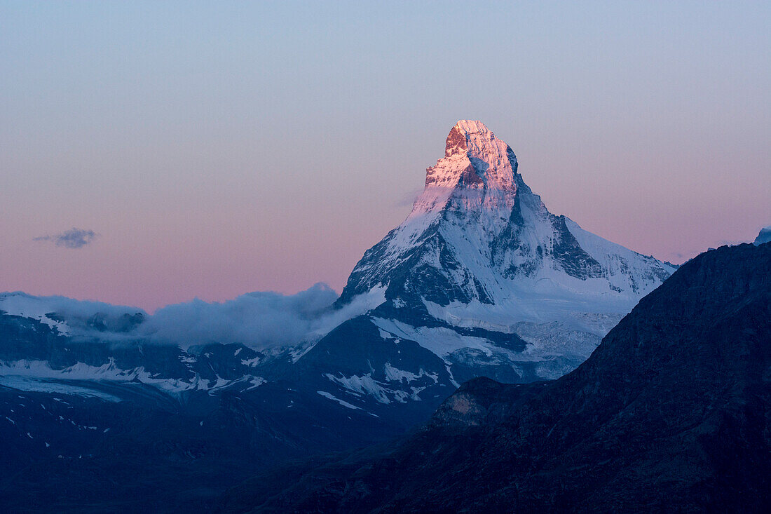 Der Gipfel des Matterhorns leuchtet rosa in der Morgendämmerung, Walliser Alpen, Kanton Wallis, Schweiz