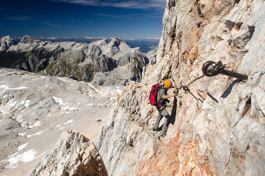 An alpine hiker or climber on the upper part of the ferrata called Bamberger Weg leading to the summit of the Triglav, Julian Alps, Slovenia