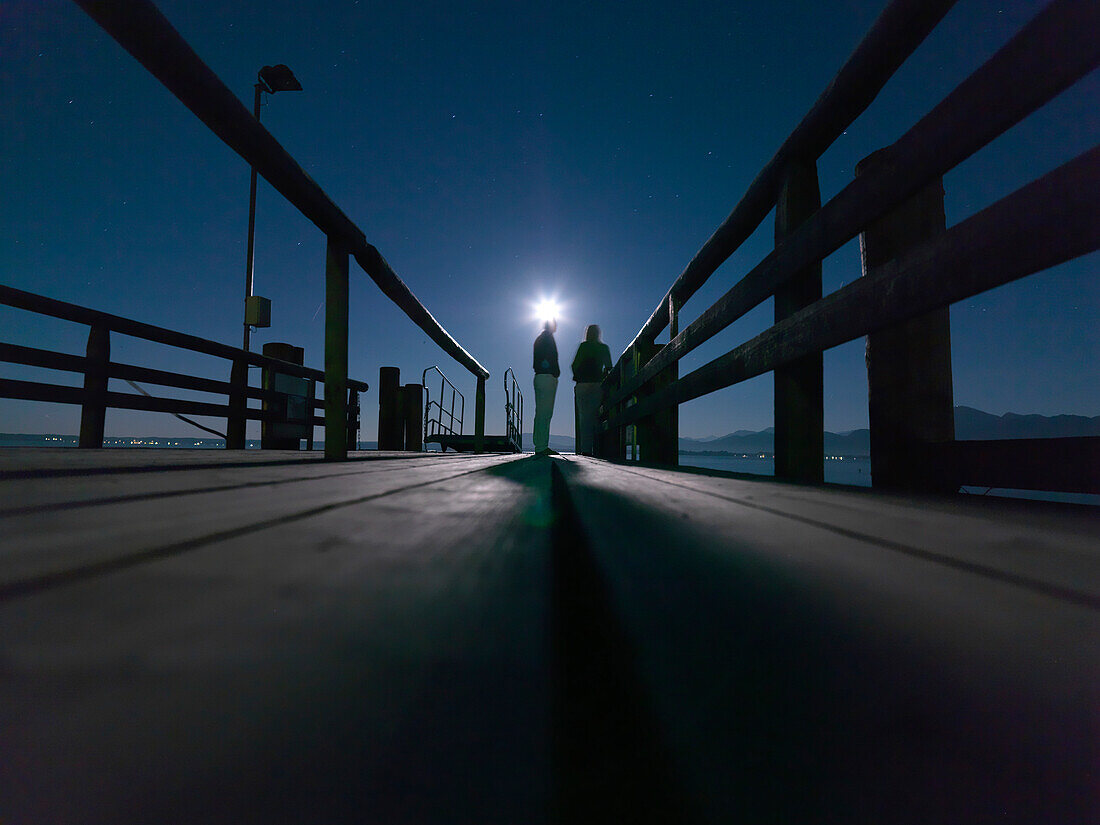 People on the pier in the moonlight, Fraueninsel, Chiemsee, Bavaria, Germany