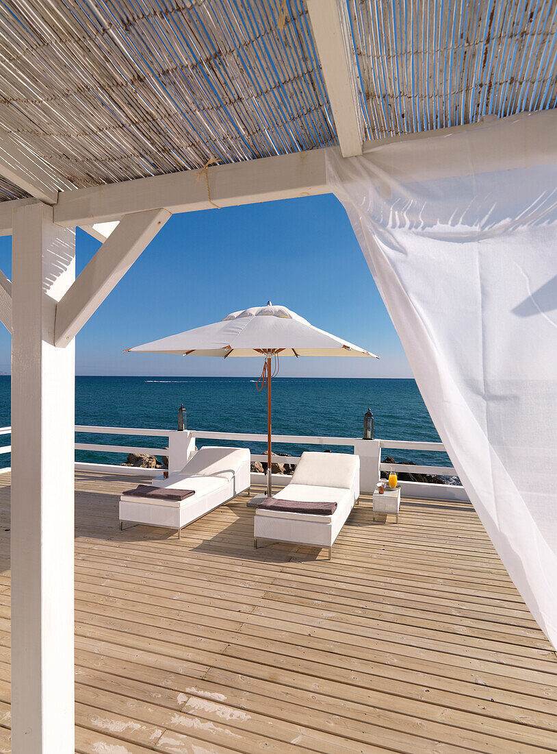 Terrace by the sea with white sun loungers, Mallorca, Balearic Islands, Spain