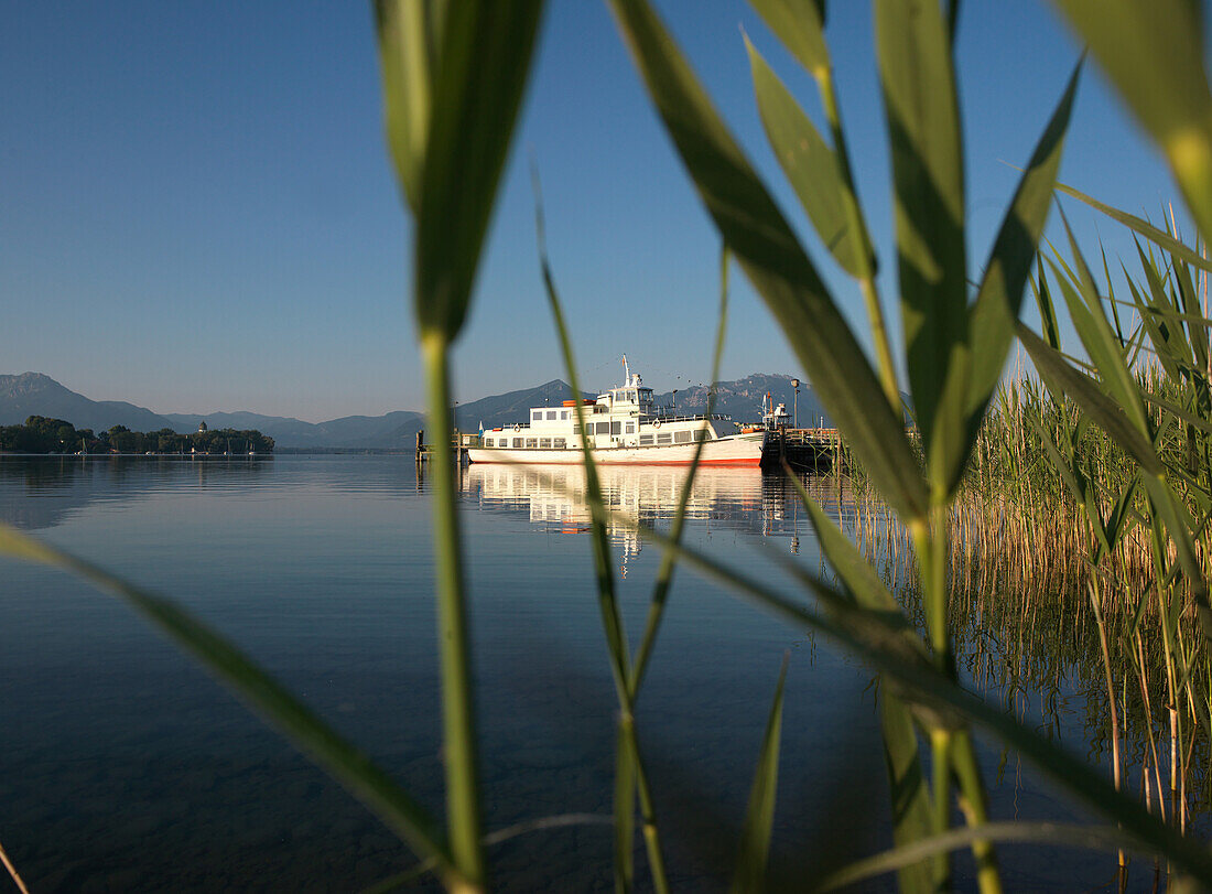 Excursion ship at a pier, island Frauenchiemsee in the background, Gstadt am Chiemsee, Upper Bavaria, Germany