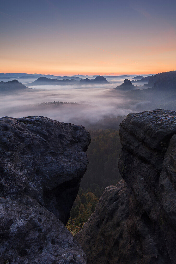 Blick vom Gleitmannshorn über den kleinen Zschand mit Nebel im Morgengrauen mit Felsen im Vordergrund, Kleiner Winterberg, Nationalpark Sächsische Schweiz, Sachsen, Deutschland