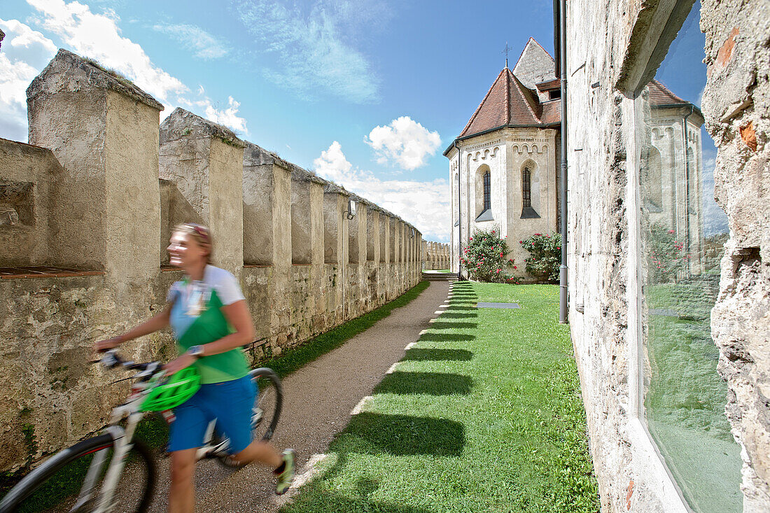 Woman pushing a bicycle, Burghausen, Chiemgau, Bavaria, Germany