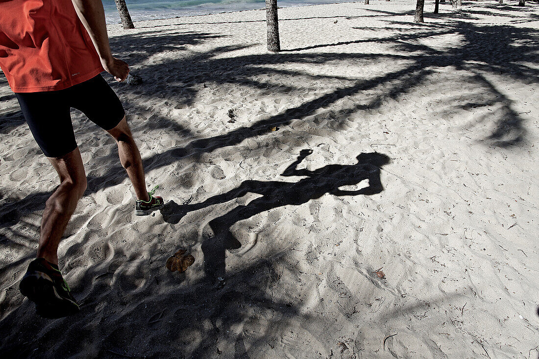 Young man running along beach, Dominica, Lesser Antilles, Caribbean