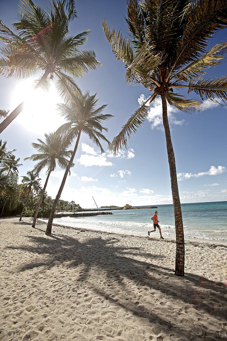 Junger Mann läuft am Strand entlang, Dominica, Kleine Antillen, Karibik