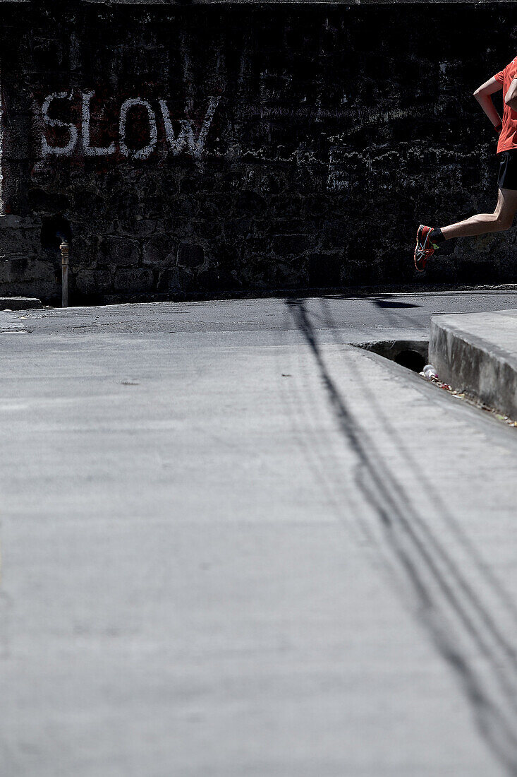 Young man running along a street, Dominica, Lesser Antilles, Caribbean