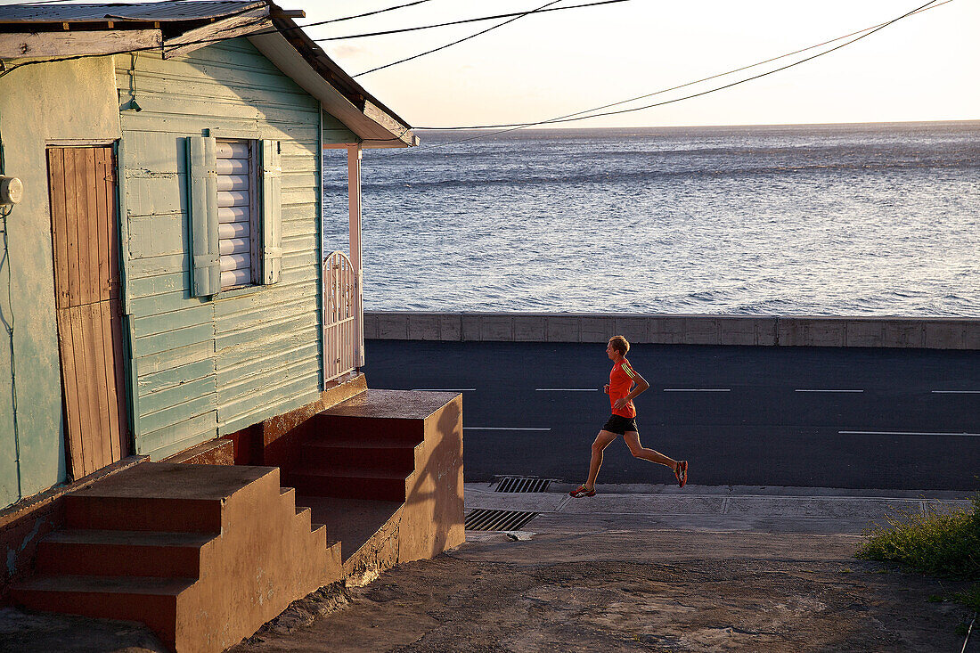 Junger Mann joggt eine Straße entlang, Dominica, Kleine Antillen, Karibik