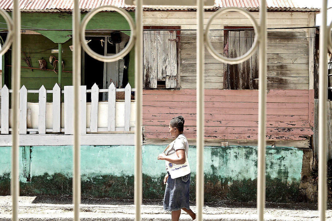 Frau läuft an einem Haus vorbei, Dominica, Kleine Antillen, Karibik