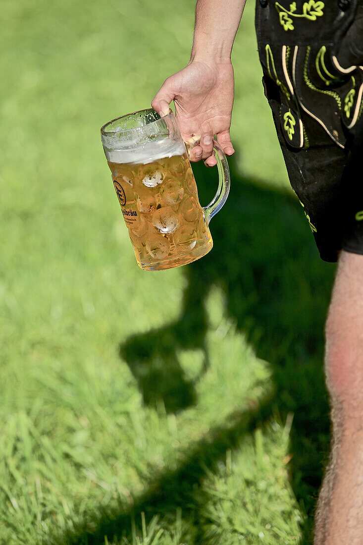 Mann in Tracht mit einem Krug Bier, Viehscheid, Allgäu, Bayern, Deutschland