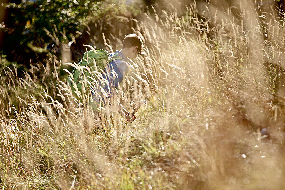 Young man hiking up a mountain on a sunny day, Oberstdorf, Bavaria, Germany