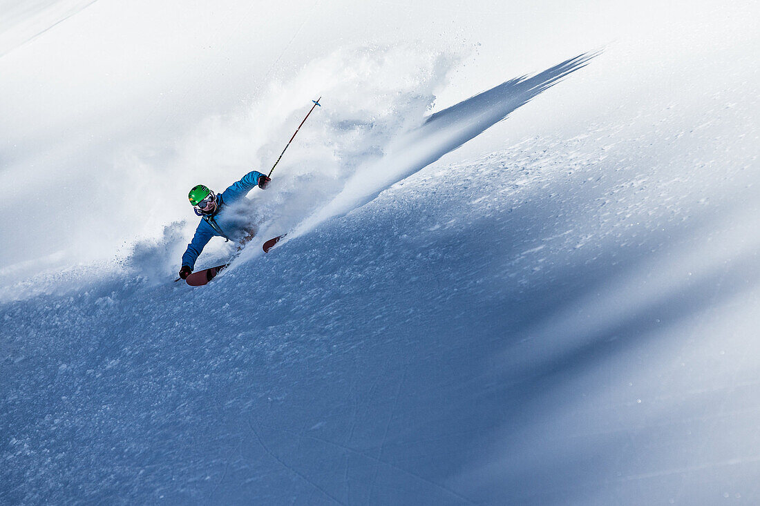 Young male freeskier riding through the deep powder snow in the mountains, Pitztal, Tyrol, Austria