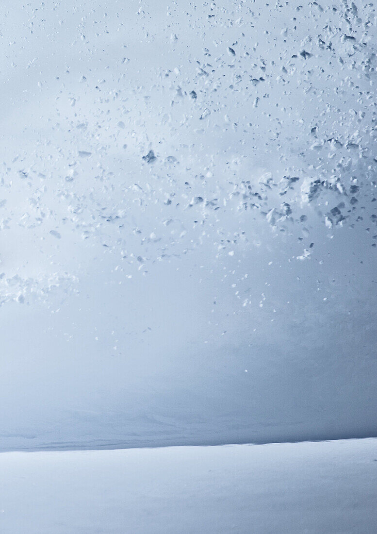 Young male snowboarder riding through deep powder snow in the mountains, Pitztal, Tyrol, Austria