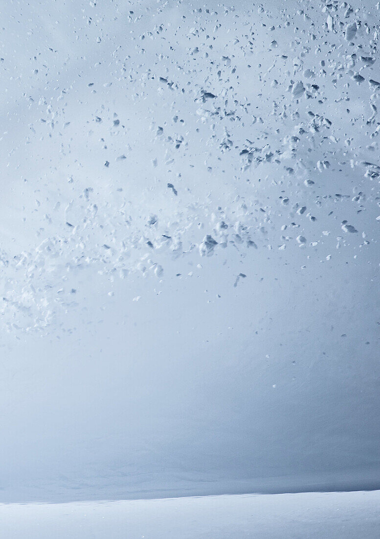 Young male snowboarder riding through deep powder snow in the mountains, Pitztal, Tyrol, Austria